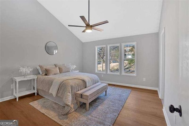 bedroom with ceiling fan, wood-type flooring, and high vaulted ceiling