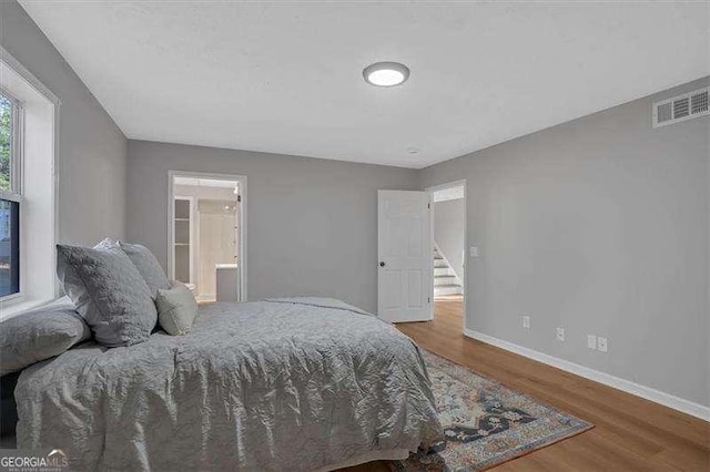 bedroom featuring wood-type flooring and connected bathroom