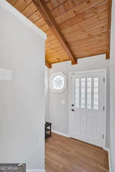 entrance foyer featuring beam ceiling, hardwood / wood-style floors, and wood ceiling