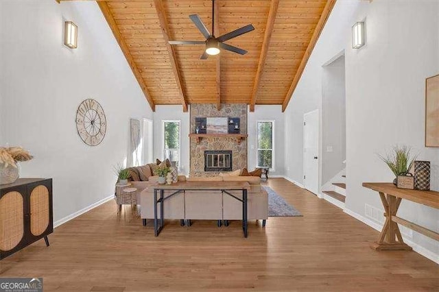 living room with ceiling fan, hardwood / wood-style flooring, high vaulted ceiling, wooden ceiling, and beamed ceiling