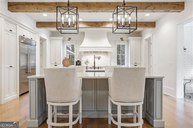 kitchen with a spacious island, pendant lighting, and stainless steel built in fridge