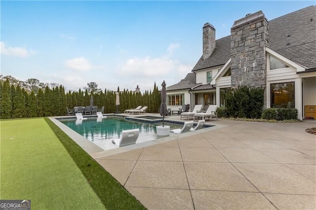 view of swimming pool with a yard and a patio