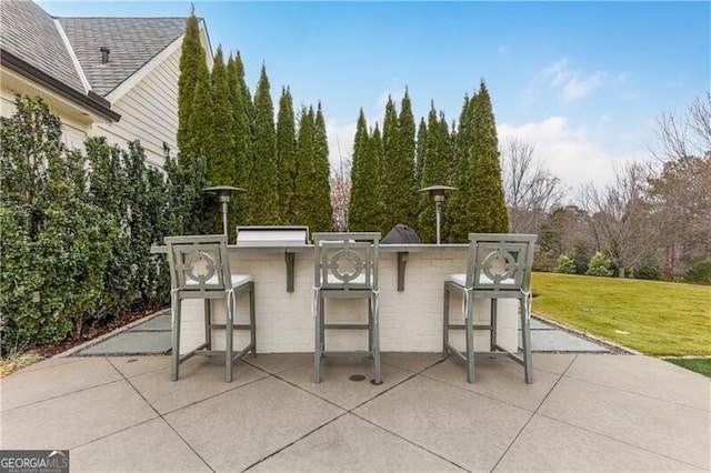 view of patio / terrace with a bar and an outdoor kitchen