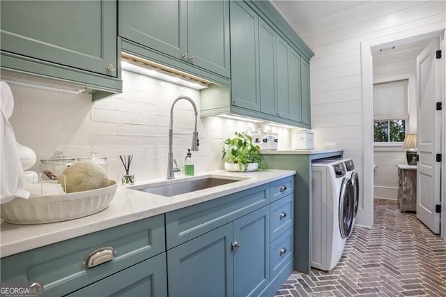 laundry area featuring cabinets, separate washer and dryer, and sink