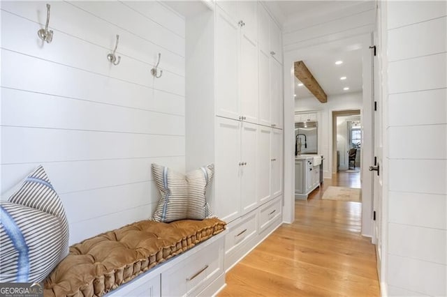 mudroom featuring beamed ceiling and light hardwood / wood-style flooring