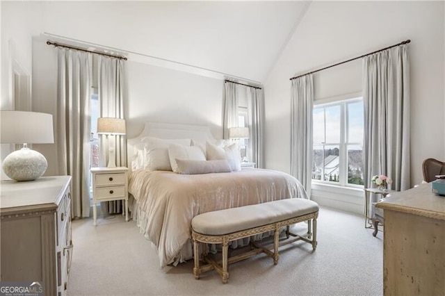 bedroom with light carpet and high vaulted ceiling