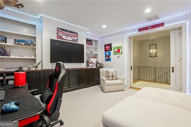 carpeted office space with built in shelves, ornamental molding, and a chandelier