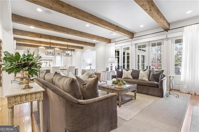 living room featuring a chandelier and beamed ceiling