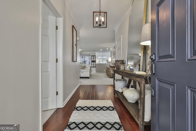 entryway featuring dark hardwood / wood-style flooring, ornamental molding, and a chandelier