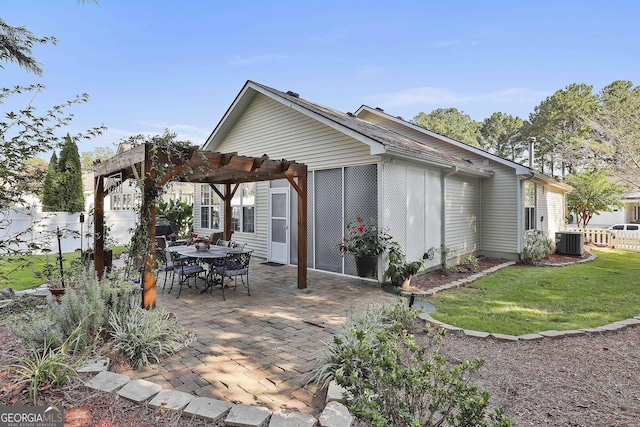 back of property with central AC unit, a patio area, a pergola, and a lawn