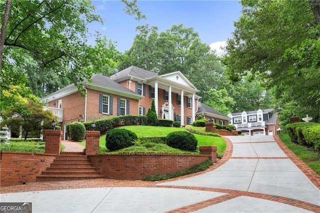 1120 Heards Ferry Rd, Sandy Springs, GA 30328 - greek revival house featuring concrete driveway, brick siding, and stairway