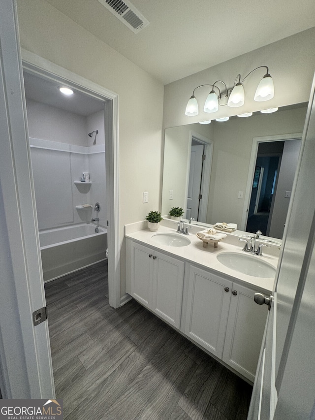 bathroom with vanity, hardwood / wood-style floors, and  shower combination