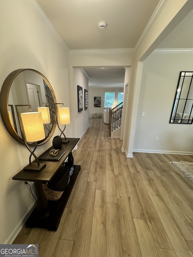 hall with ornamental molding and light hardwood / wood-style flooring