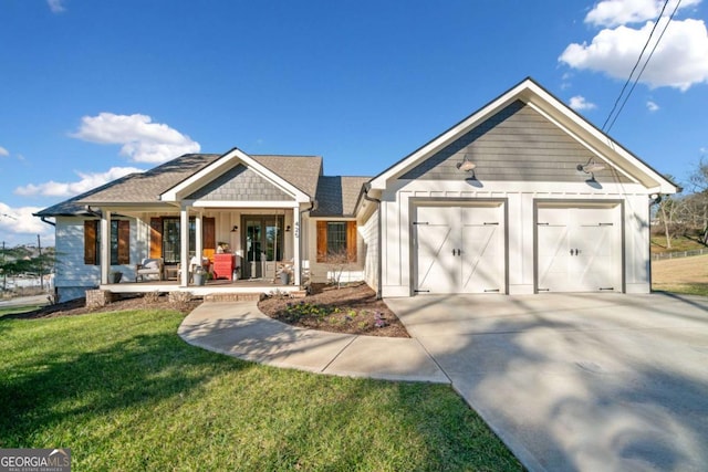 view of front of property with a front lawn, covered porch, and a garage