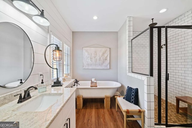 bathroom featuring vanity, plus walk in shower, and wood-type flooring