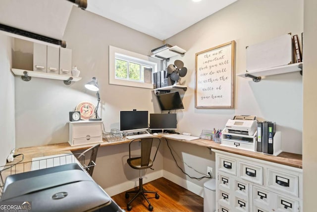 home office featuring built in desk and dark hardwood / wood-style floors