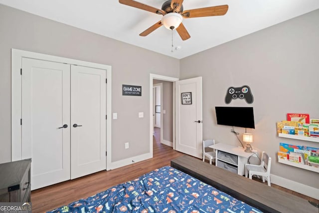 bedroom featuring ceiling fan, a closet, and dark wood-type flooring