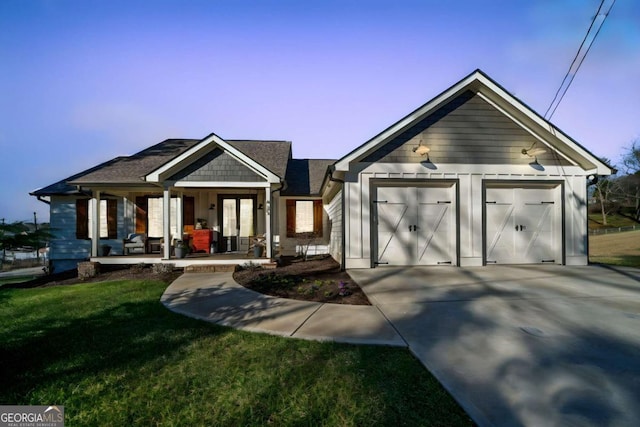 view of front of property with a lawn, a porch, and a garage