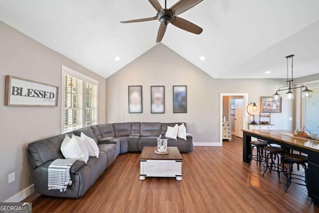 living room with ceiling fan, dark hardwood / wood-style flooring, and vaulted ceiling