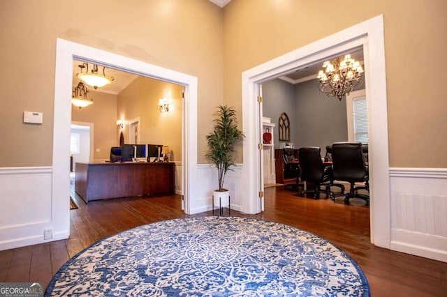 interior space with a chandelier, ornamental molding, and dark wood-type flooring