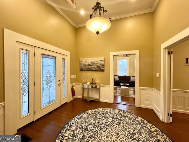 foyer entrance with crown molding and dark hardwood / wood-style floors