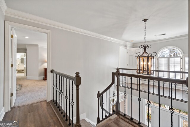 living area with built in shelves, an inviting chandelier, crown molding, and dark hardwood / wood-style floors