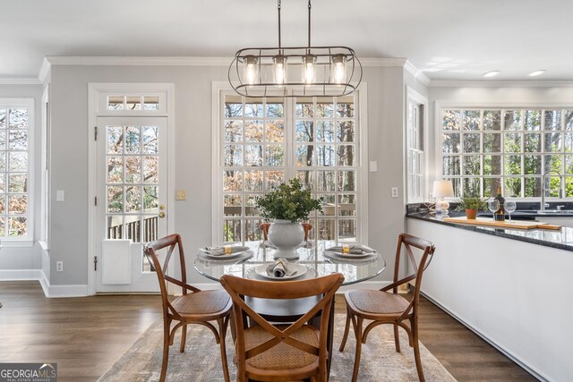 kitchen with dark hardwood / wood-style flooring, white cabinets, dark stone countertops, and crown molding