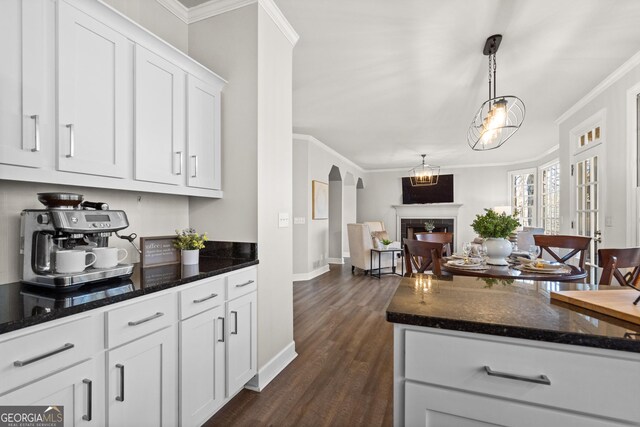 bar with ornamental molding, dark hardwood / wood-style flooring, and white cabinetry