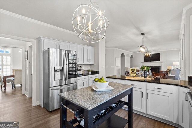 dining space featuring hardwood / wood-style floors, a fireplace, and ornamental molding