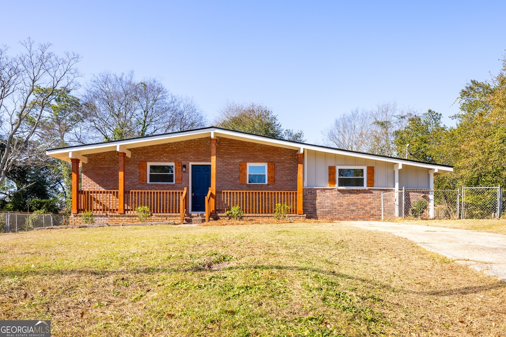 ranch-style home with a front lawn and covered porch