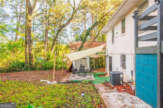 view of yard featuring a patio, central AC, and a shed