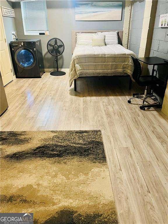 bedroom with washer / clothes dryer and light hardwood / wood-style floors