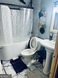 bathroom with shower / bath combo and toilet