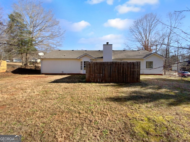 rear view of house featuring a lawn