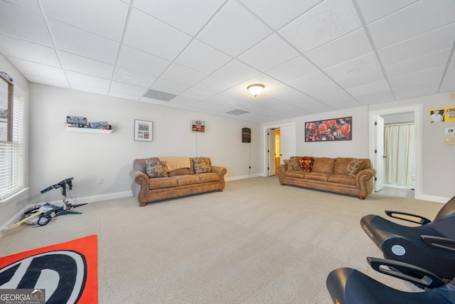 living room featuring carpet and a paneled ceiling