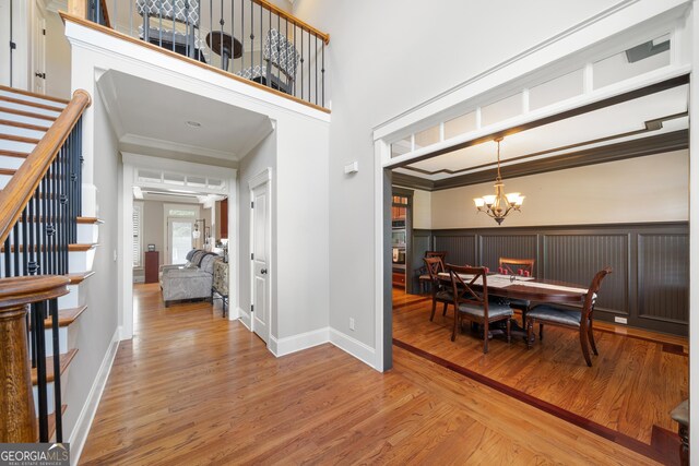 dining room with an inviting chandelier, wood-type flooring, and ornamental molding