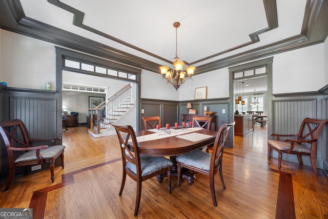 dining room with a chandelier, light hardwood / wood-style floors, and ornamental molding