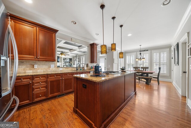 kitchen featuring coffered ceiling, stainless steel appliances, beam ceiling, a center island, and hanging light fixtures