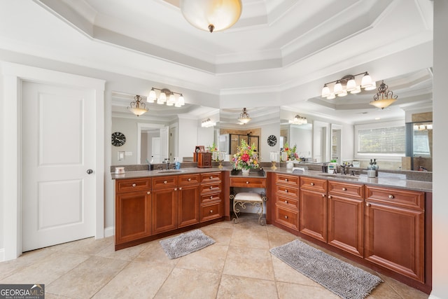 bathroom with a raised ceiling, vanity, crown molding, and tile patterned floors