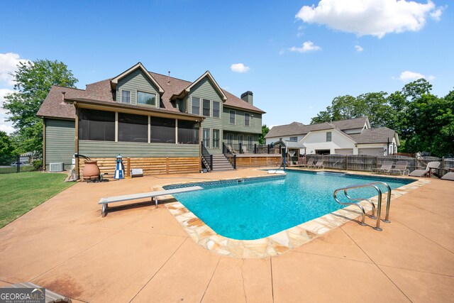 view of swimming pool featuring a sunroom, a diving board, a patio, and central AC