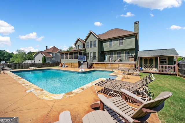 view of pool with a sunroom, a patio, a diving board, and a lawn