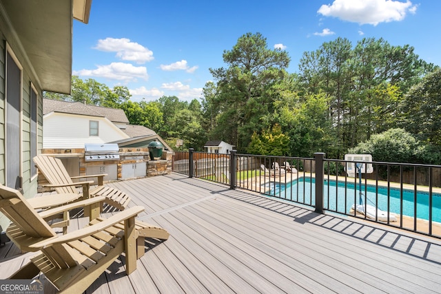 wooden terrace with a fenced in pool, area for grilling, a patio area, and exterior kitchen