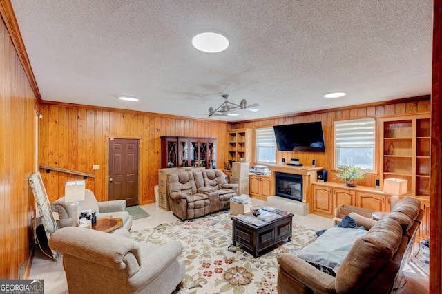 living room with ceiling fan, ornamental molding, and wood walls