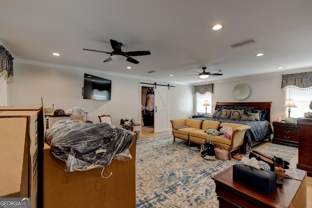 bedroom with a barn door, a closet, a spacious closet, and ceiling fan