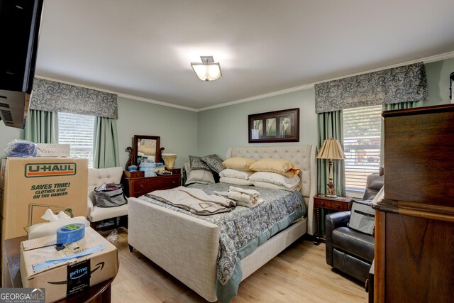 bedroom with crown molding and light hardwood / wood-style flooring