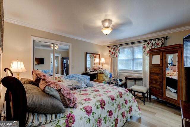 bedroom featuring ceiling fan, a closet, light wood-type flooring, and ornamental molding