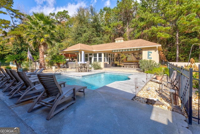 view of pool featuring a patio area and a sunroom