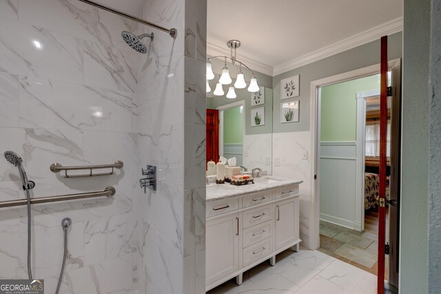 bathroom with a tile shower, vanity, an inviting chandelier, and crown molding