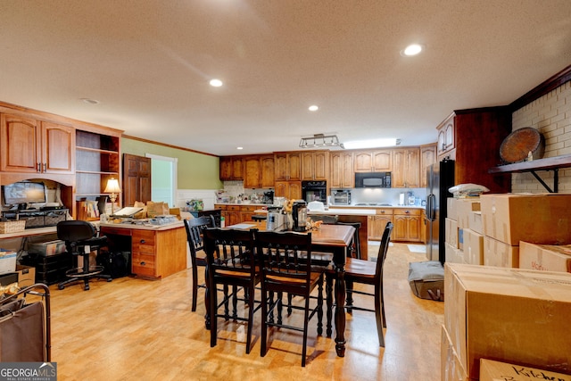 dining space with crown molding, a textured ceiling, and light wood-type flooring