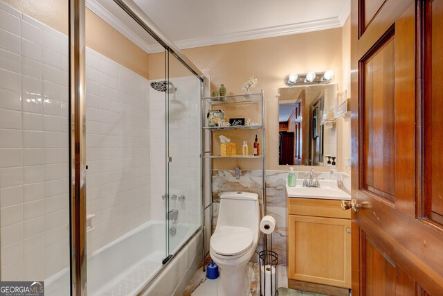 full bathroom with vanity, toilet, ornamental molding, and enclosed tub / shower combo